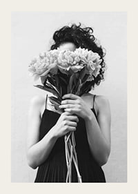 Schwarz-Weiß-Foto einer Frau mit lockigem Haar, die einen Blumenstrauß hält-3