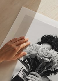 Schwarz-Weiß-Foto einer Frau mit lockigem Haar, die einen Blumenstrauß hält-9