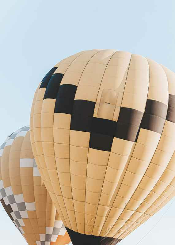 Photograph of yellow and black hot air balloons against blue sky-12