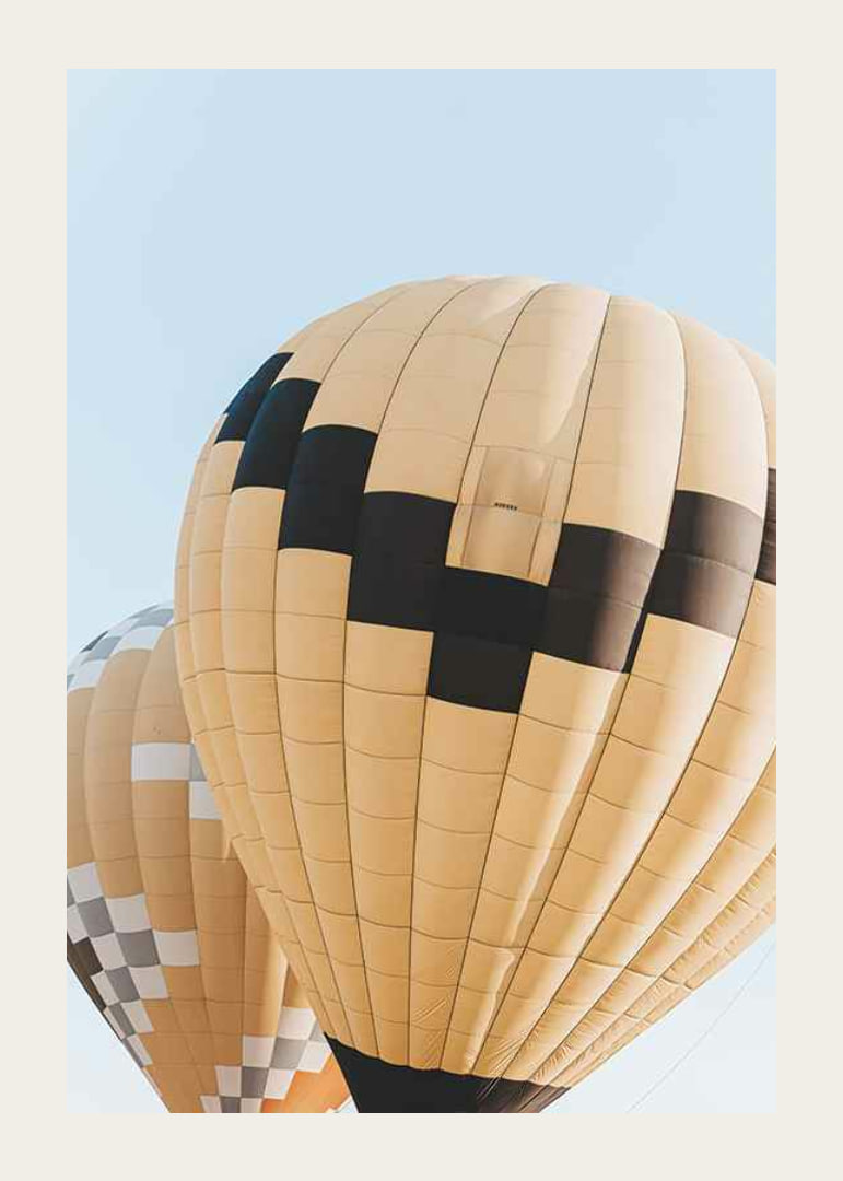 Photograph of yellow and black hot air balloons against blue sky-12