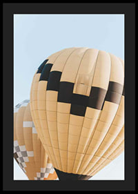 Photograph of yellow and black hot air balloons against blue sky-4