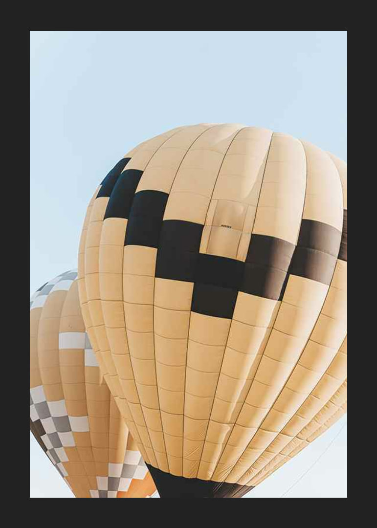 Photograph of yellow and black hot air balloons against blue sky-12
