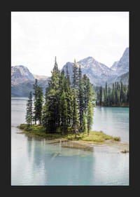 Fotografía de un bosque de abetos en una pequeña isla en un lago azul claro con montañas.-5