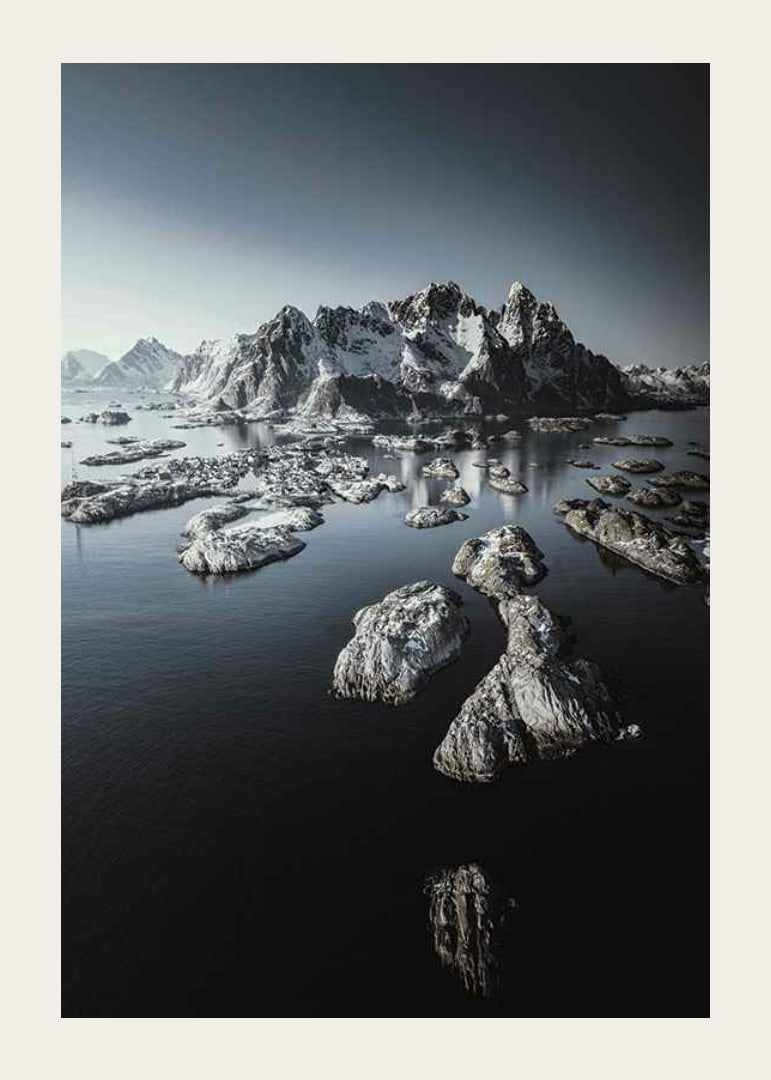 Photograph of snow-capped mountains and small islands on a dark sea-12