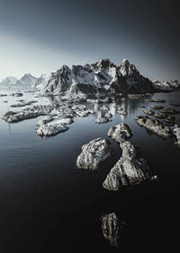 Photograph of snow-capped mountains and small islands on a dark sea-7