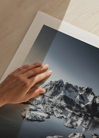 Photograph of snow-capped mountains and small islands on a dark sea-9