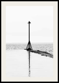 Svartvitt fotografi av sjömärke vid vattnet med spegling-2