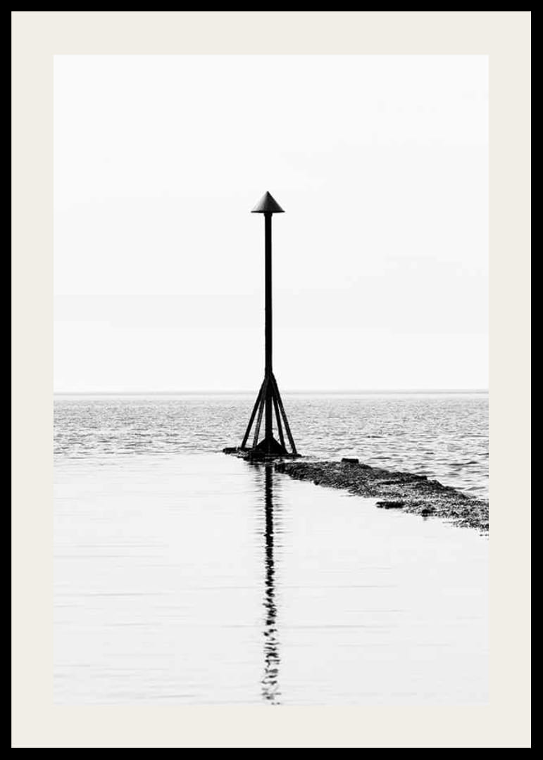 Svartvitt fotografi av sjömärke vid vattnet med spegling-12