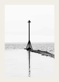 Svartvitt fotografi av sjömärke vid vattnet med spegling-3