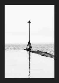 Svartvitt fotografi av sjömärke vid vattnet med spegling-5