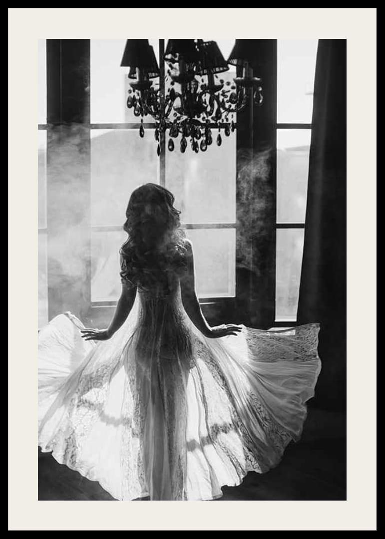 Fekete-fehér fénykép egy csipkeruhás nőről az ablak mellett-12