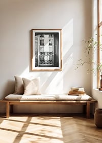 Black and white photo of open window with wrought iron balcony-8