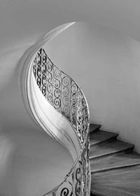 Black and white photograph of spiral staircase with wrought iron railing-7