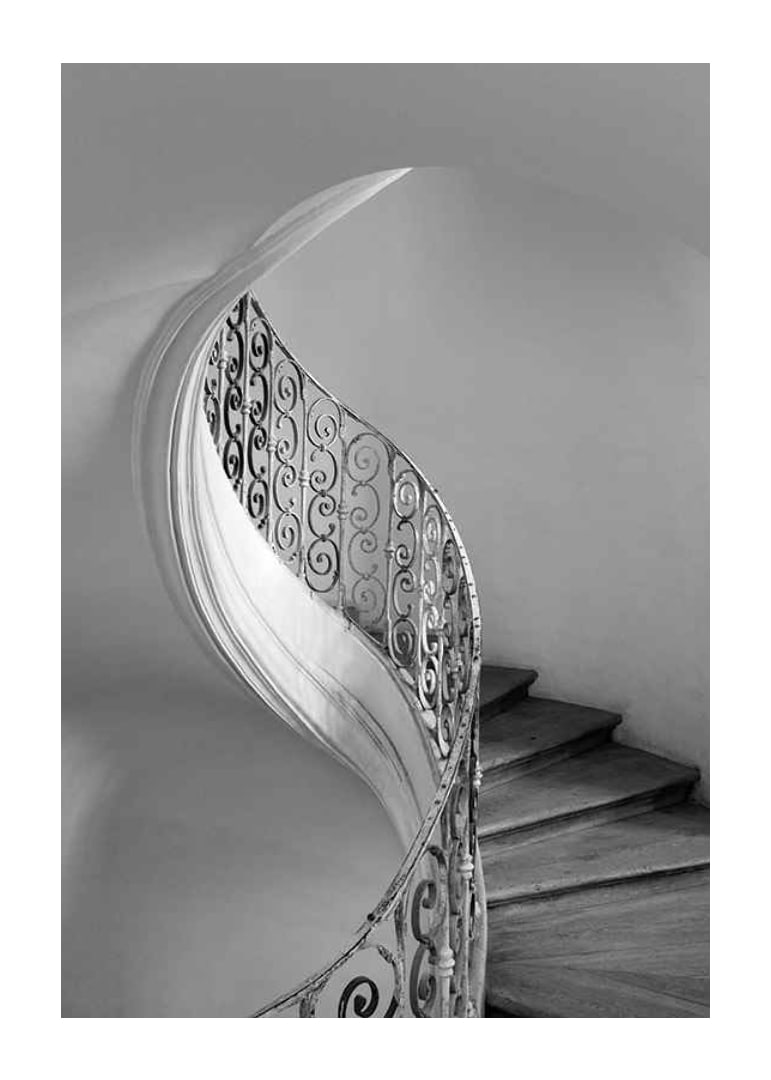 Black and white photograph of spiral staircase with wrought iron railing-12