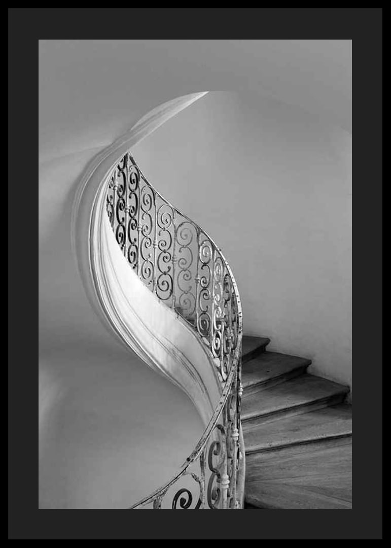 Black and white photograph of spiral staircase with wrought iron railing-12