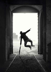 Black and white photograph of jumping man with umbrella in tunnel-7