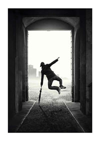 Black and white photograph of jumping man with umbrella in tunnel-1