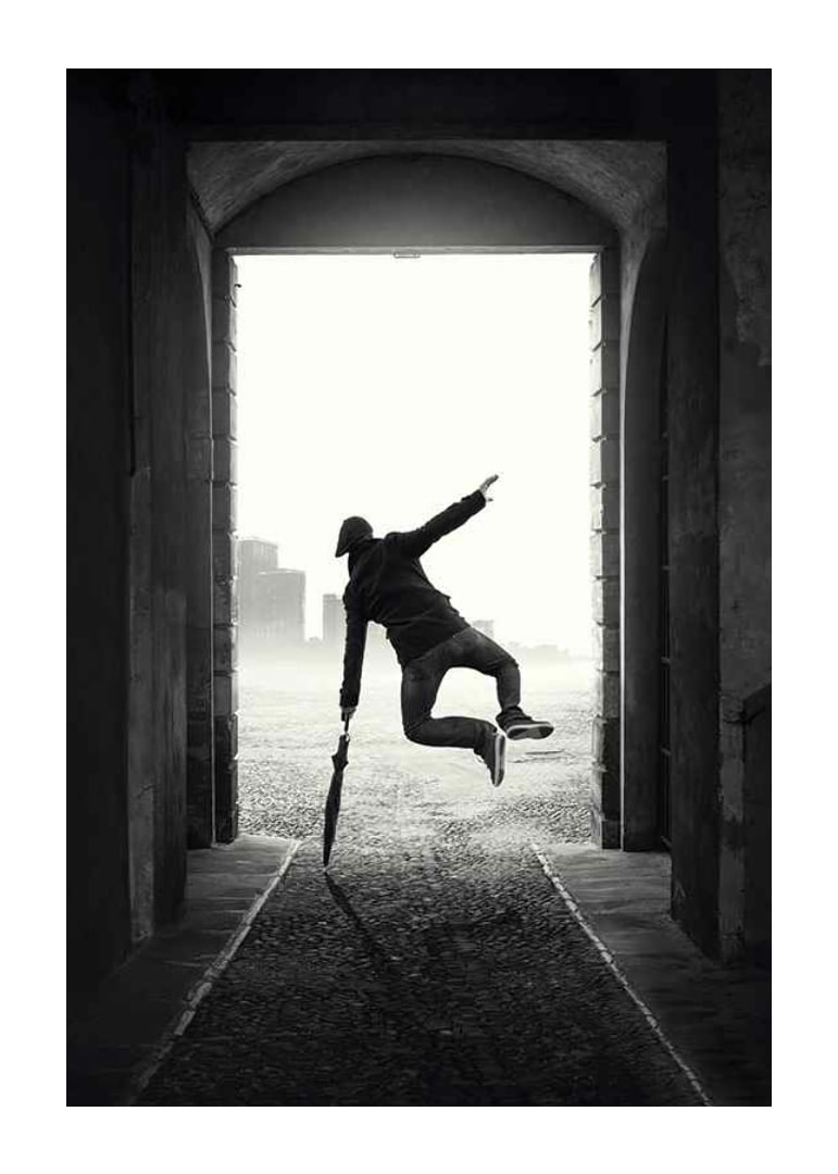 Black and white photograph of jumping man with umbrella in tunnel-12