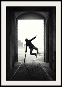 Black and white photograph of jumping man with umbrella in tunnel-2