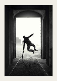 Black and white photograph of jumping man with umbrella in tunnel-3