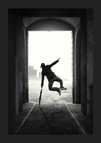Black and white photograph of jumping man with umbrella in tunnel-5