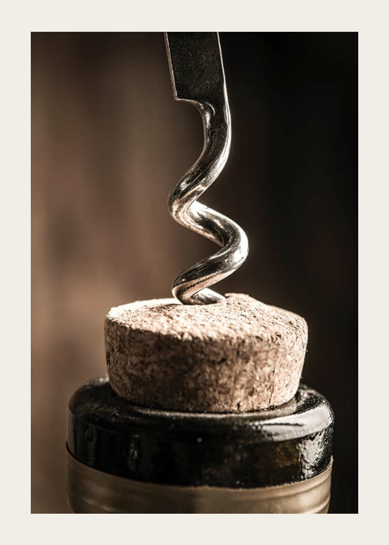 Close-up of corkscrew in wine bottle with warm tone-12