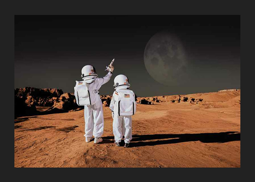Two children in astronaut suits on red desert against dark sky-12
