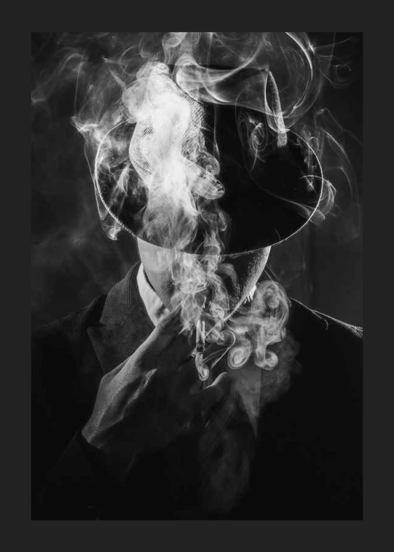 Black and white portrait of man in hat surrounded by cigarette smoke-12
