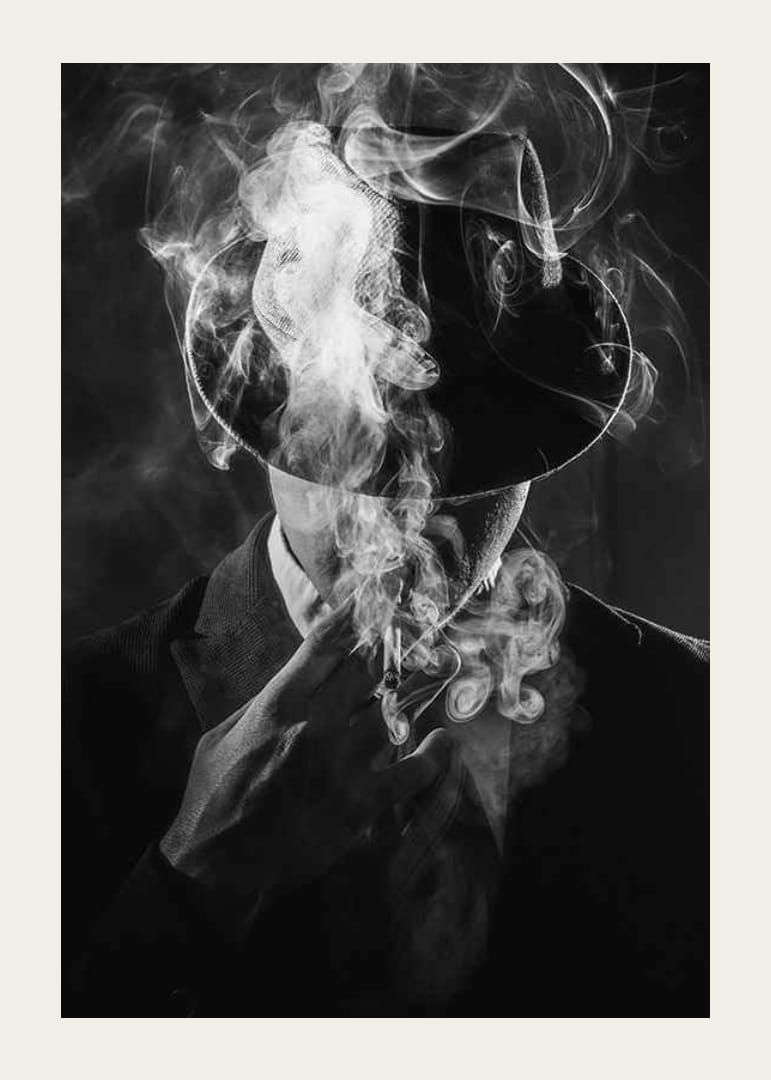 Black and white portrait of man in hat surrounded by cigarette smoke-12