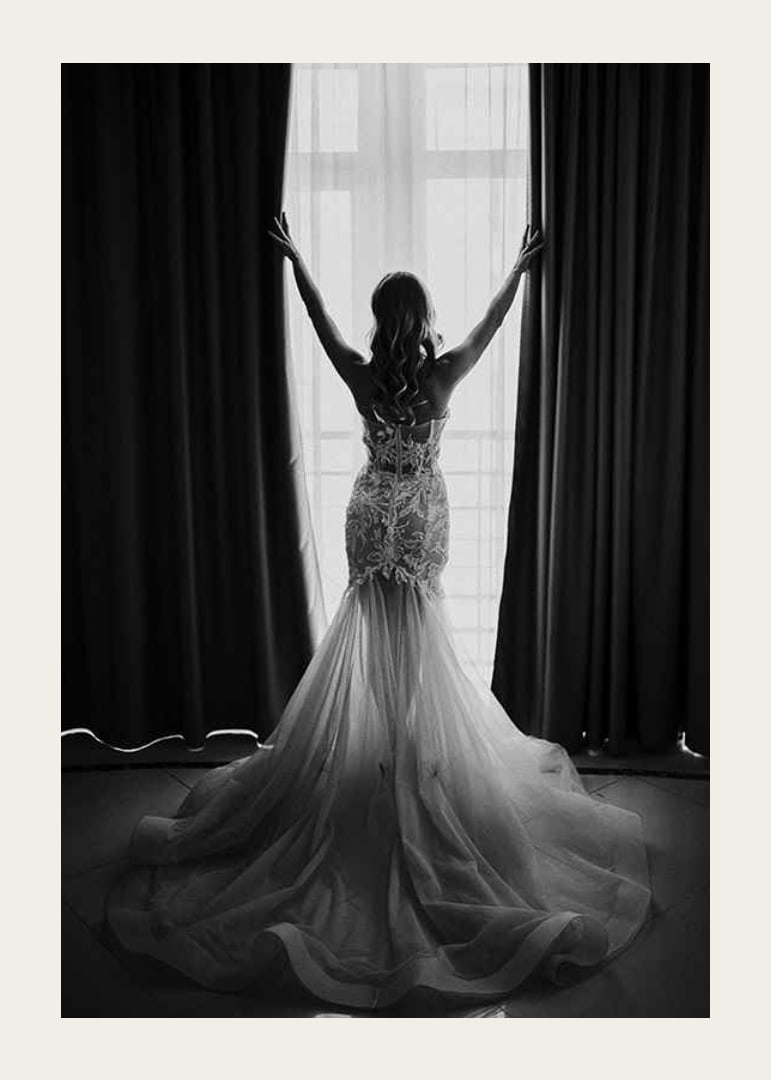 Black and white photo of woman in lace dress by open window-12
