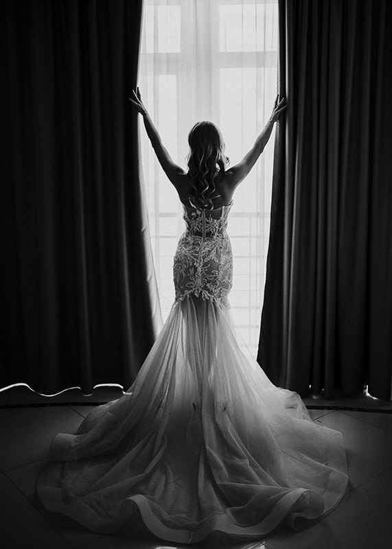 Black and white photo of woman in lace dress by open window-12