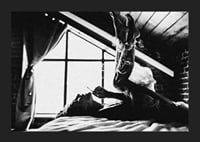 Black and white photograph of woman smoking in bed by window-5