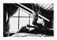 Black and white photograph of woman smoking in bed by window-1