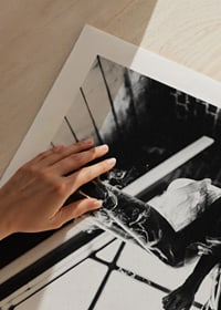Black and white photograph of woman smoking in bed by window-9