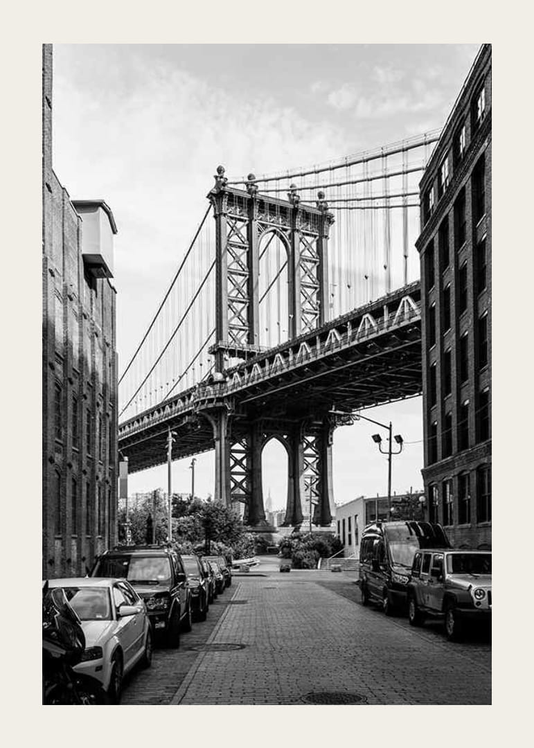 Black and white photograph of Manhattan Bridge between buildings-12