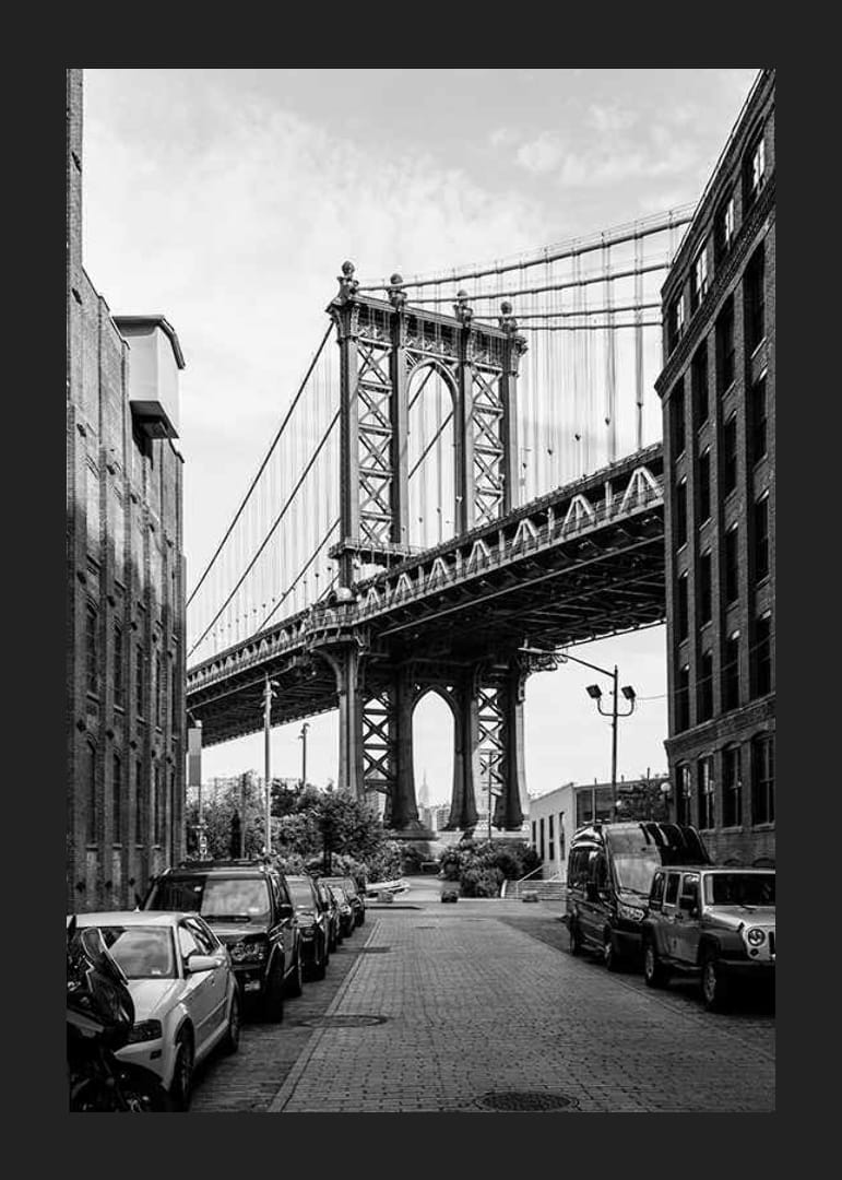 Black and white photograph of Manhattan Bridge between buildings-12