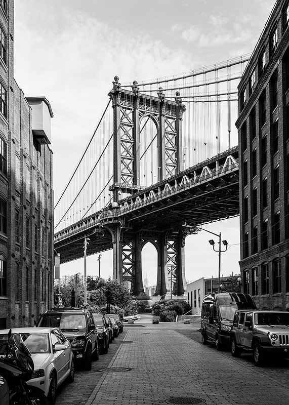 Black and white photograph of Manhattan Bridge between buildings-12