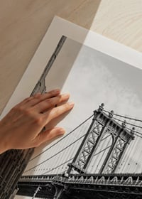Black and white photograph of Manhattan Bridge between buildings-9