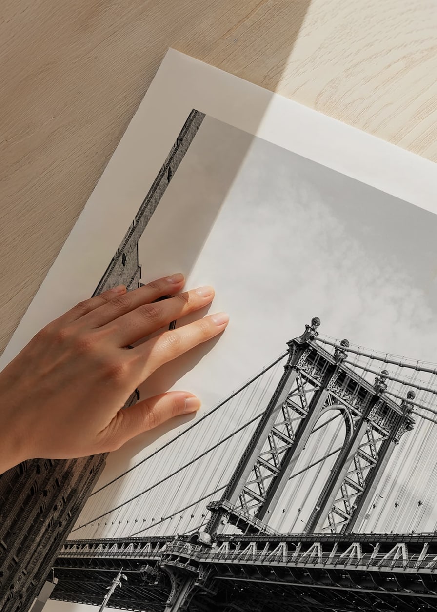 Black and white photograph of Manhattan Bridge between buildings-12