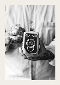 Black and white photo of tattooed hands holding a retro camera-3
