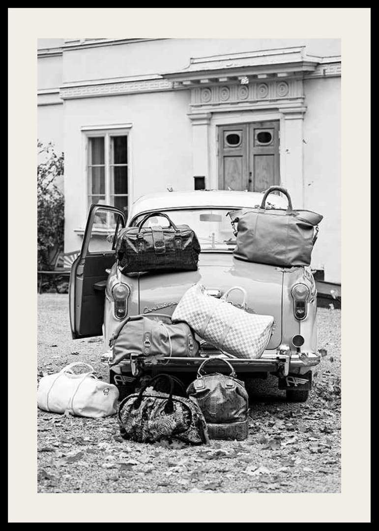 Svartvit fotokonst med gammal bil och resväskor utanför hus-12