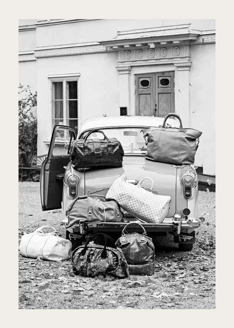 Black and white photo art with old car and suitcases outside house-12