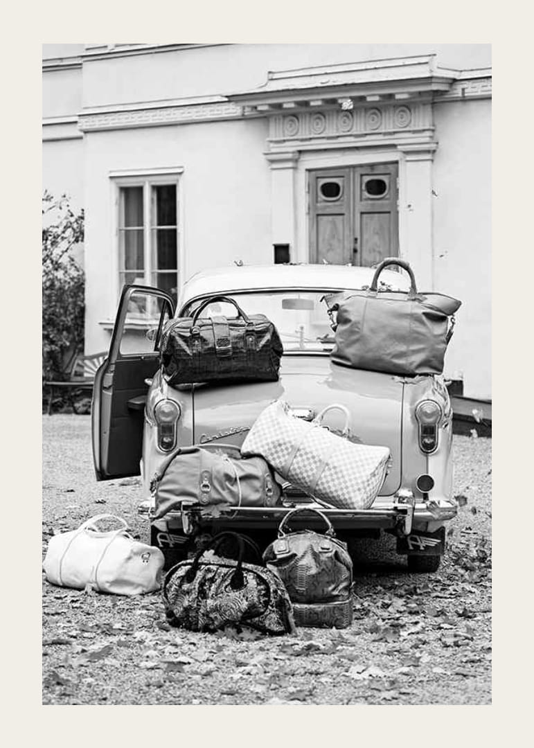 Svartvit fotokonst med gammal bil och resväskor utanför hus-12