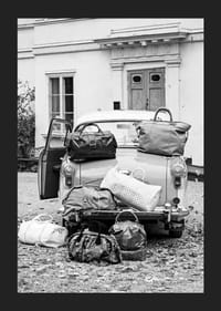 Svartvit fotokonst med gammal bil och resväskor utanför hus-5