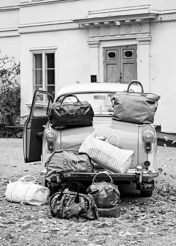 Black and white photo art with old car and suitcases outside house-12