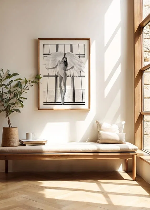 Black and white photo of woman with angel wings by large window-12
