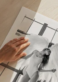 Black and white photo of woman with angel wings by large window-9