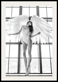 Black and white photo of woman with angel wings by large window-2