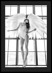Black and white photo of woman with angel wings by large window-4
