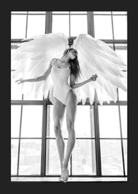 Foto in bianco e nero di una donna con ali d'angelo vicino a una grande finestra-5